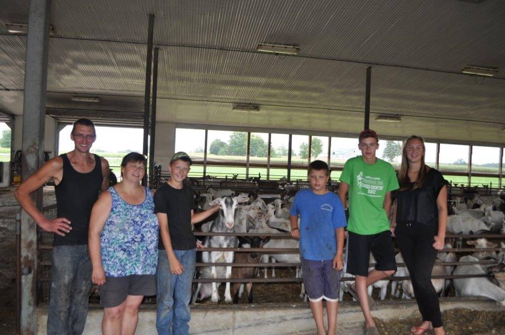 Anja & Henry van der Vlies and family standing in the barn with goats